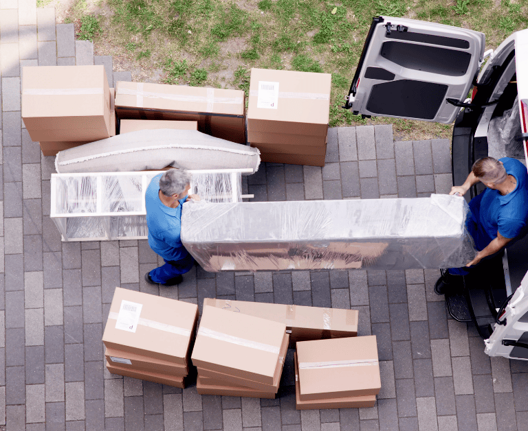 operarios realizando mudanza y cargando muebles en furgoneta en Siero